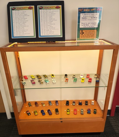 display case with toy cars and trucks